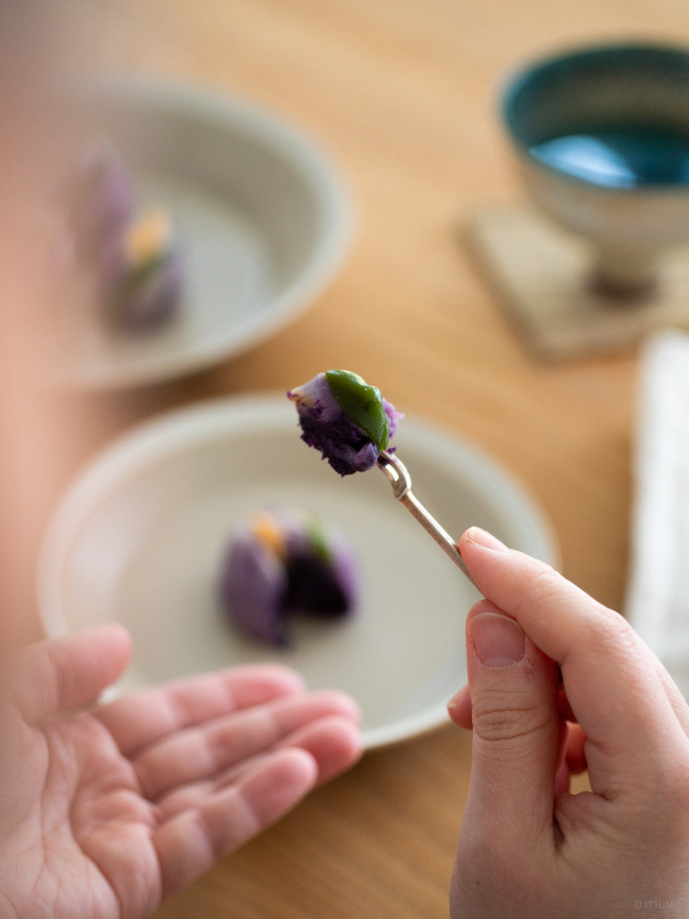Small Azmaya brass fork holding a piece of Japanese mochi dessert