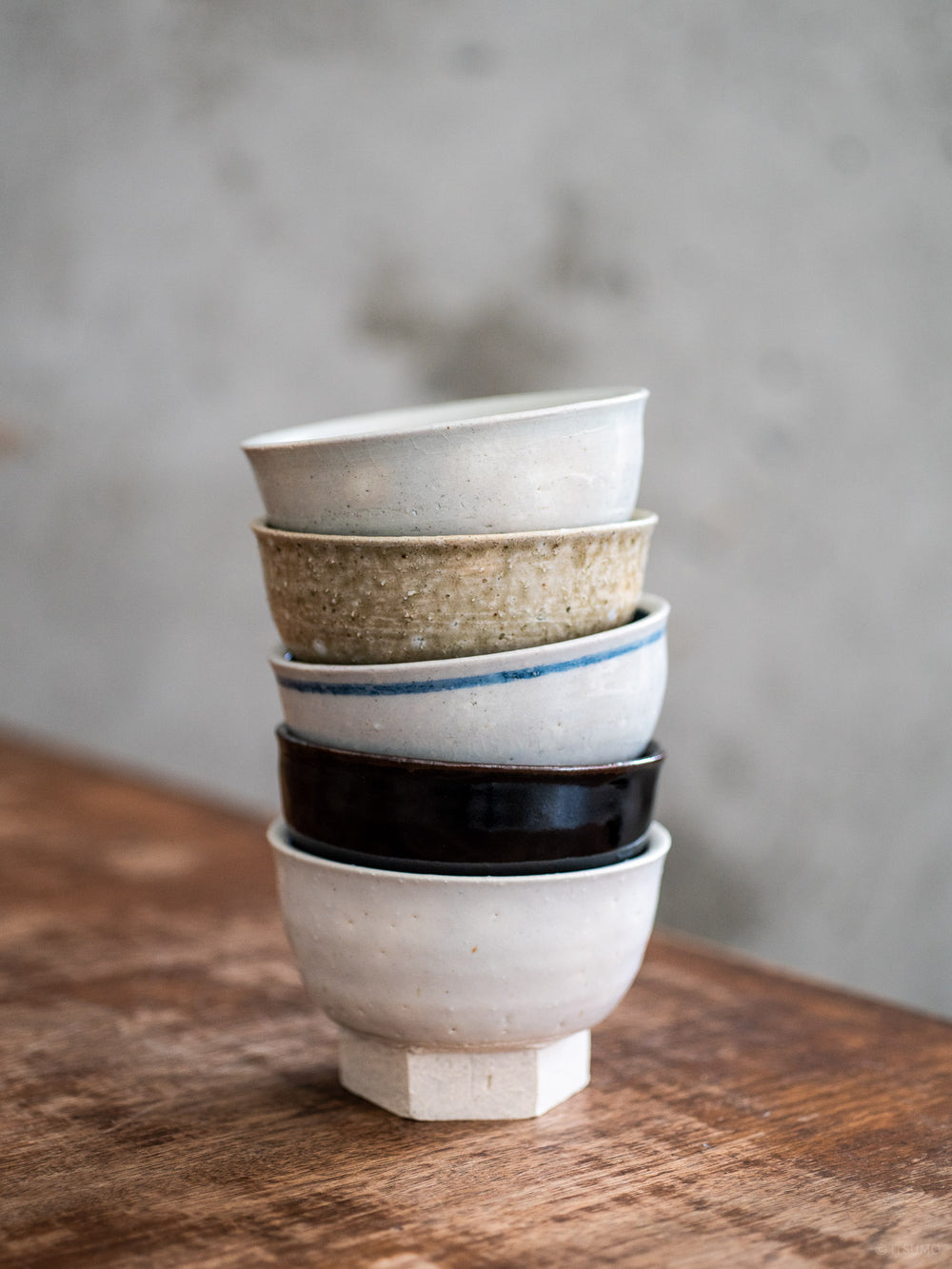 Six small iga ware bowls with a hexagon base, each with different glaze