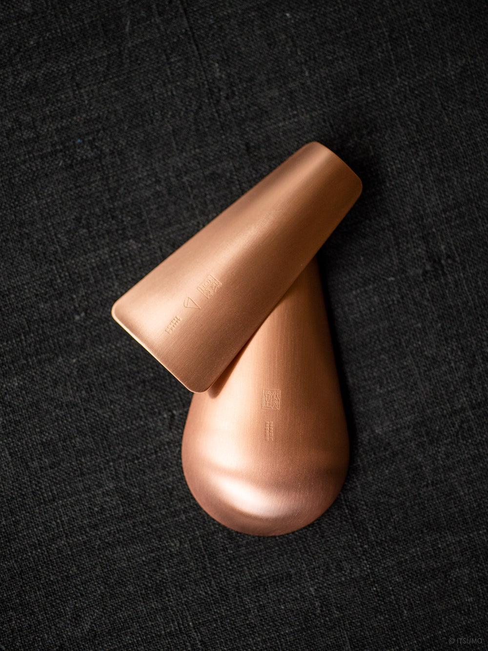 Azmaya copper tea scoops in flat shape and pear shape showing the brand stamp on the bottom