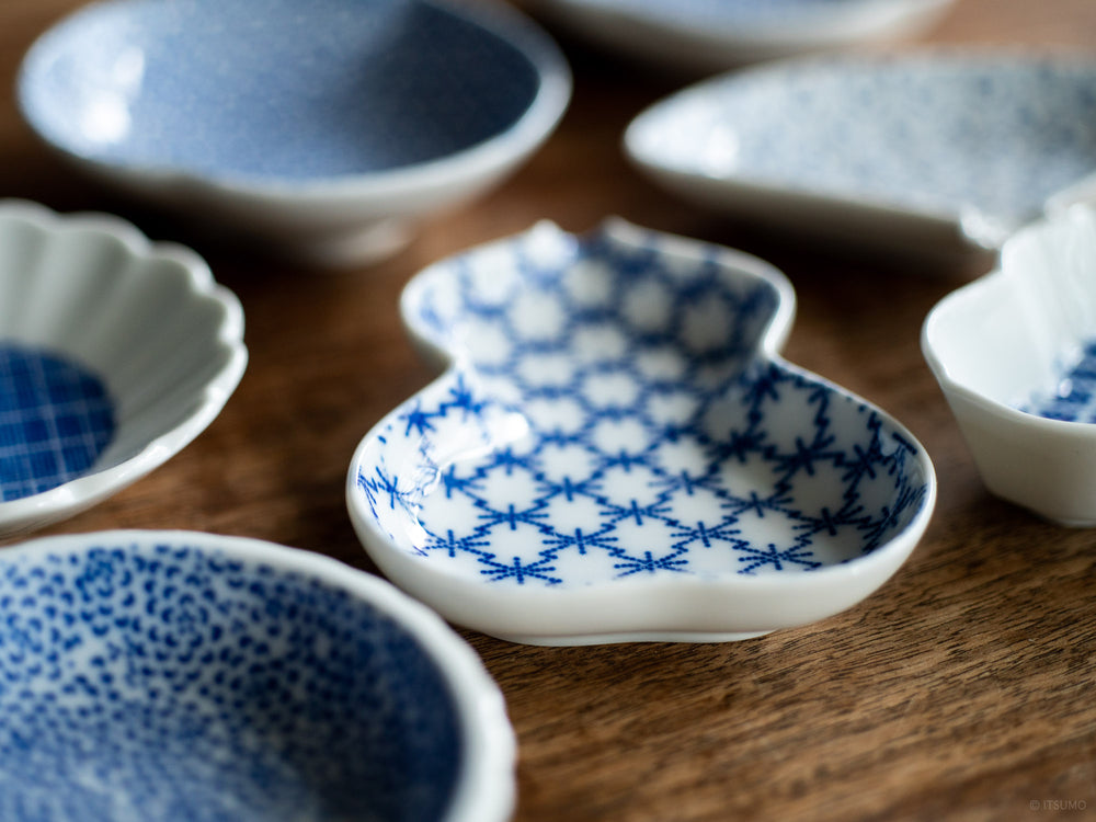 Close up of small white Azmaya Mamezara dishes with blue textured patterns inside