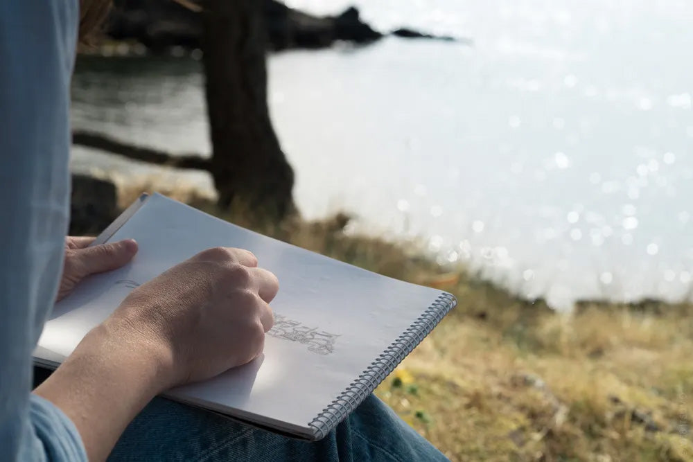 Drawing in a sketchbook facing the ocean on Bowen Island, BC
