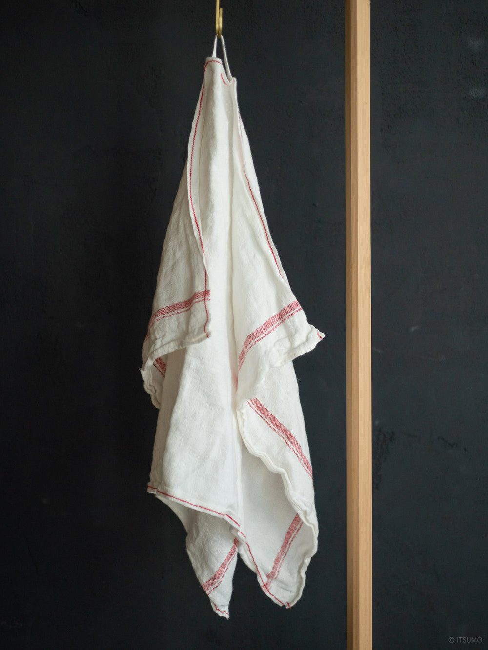 Azmaya white azabu linen kitchen cloth with a red stripe along the edge, hanging from a hook