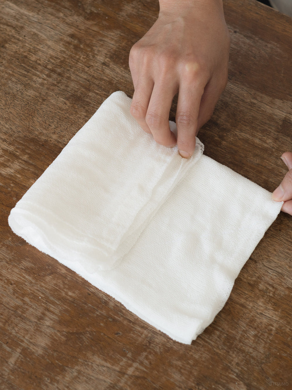 Folding a white Azmaya fukin cleaning cloth