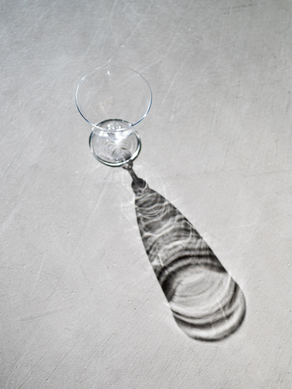 Azmaya handblown wine glass creating a long decorative shadow