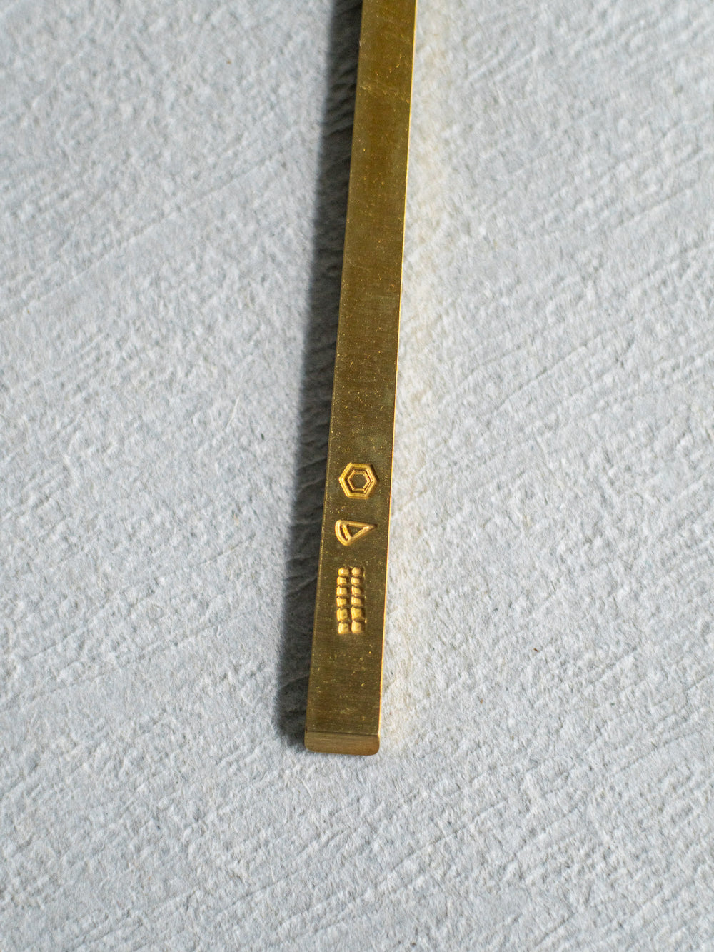 Close up view of the stamp on the brass handle of Azmaya's small fork