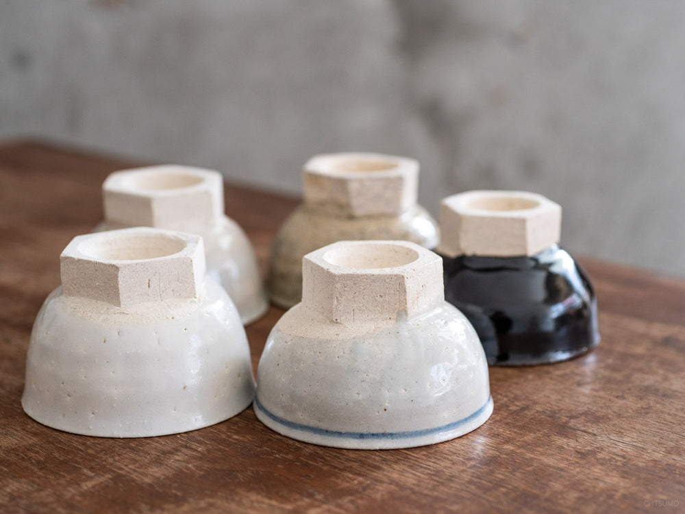 Six small iga ware ceramic bowls, upside down, showing the hexagon base