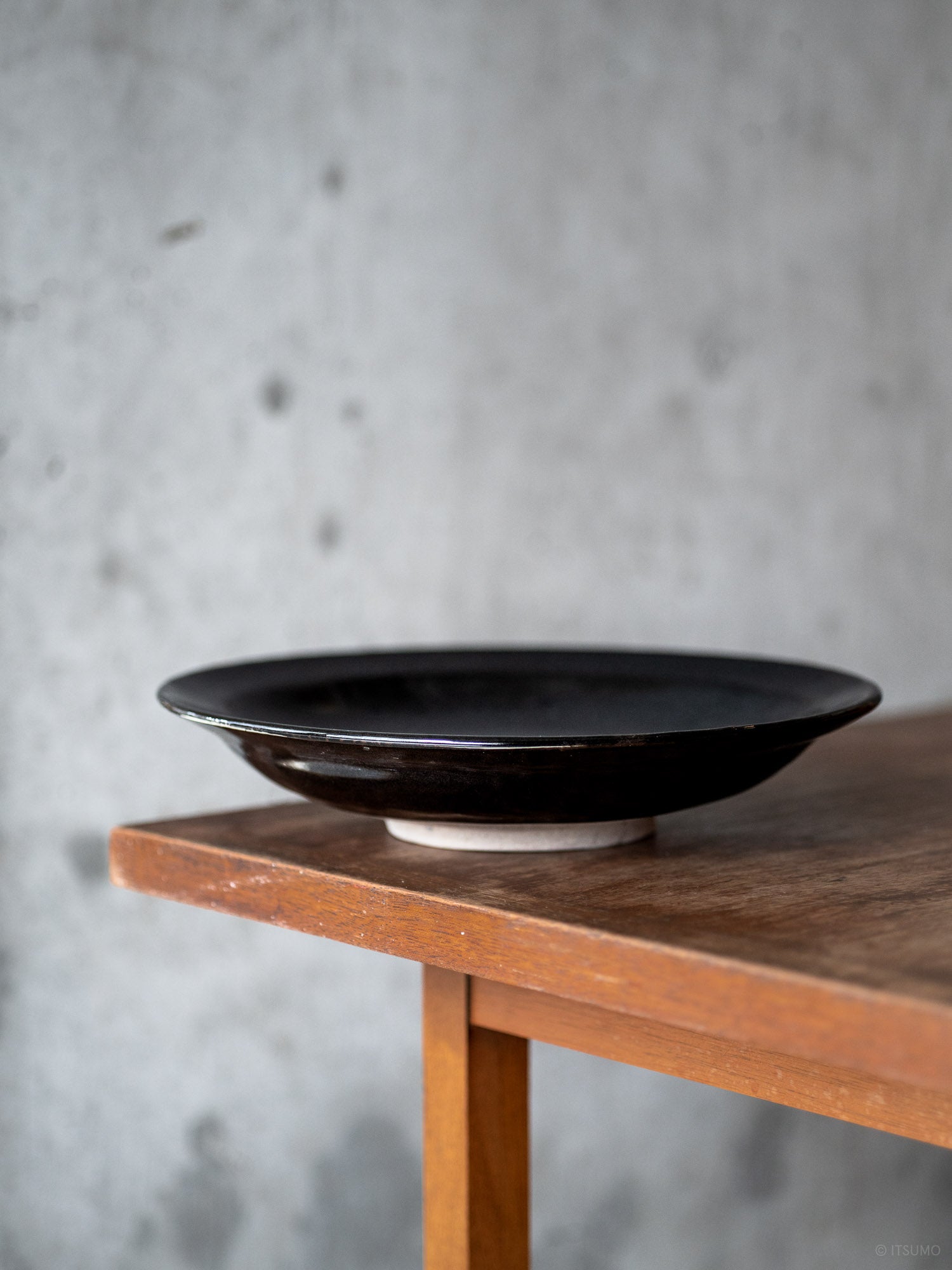 Iga ware round ceramic plate in Kuroame black glaze