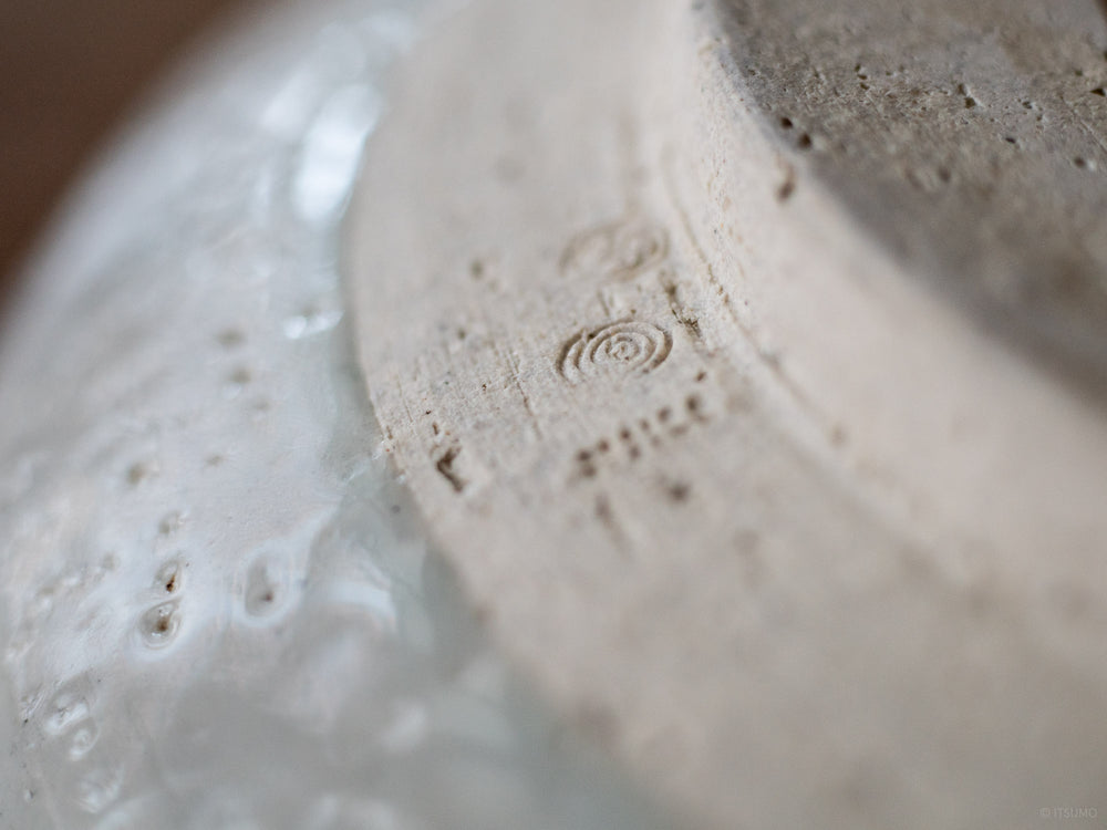 Close up detail of a ceramic stamp on the bottom of Azmaya's large serving bowl in white sekkai glaze