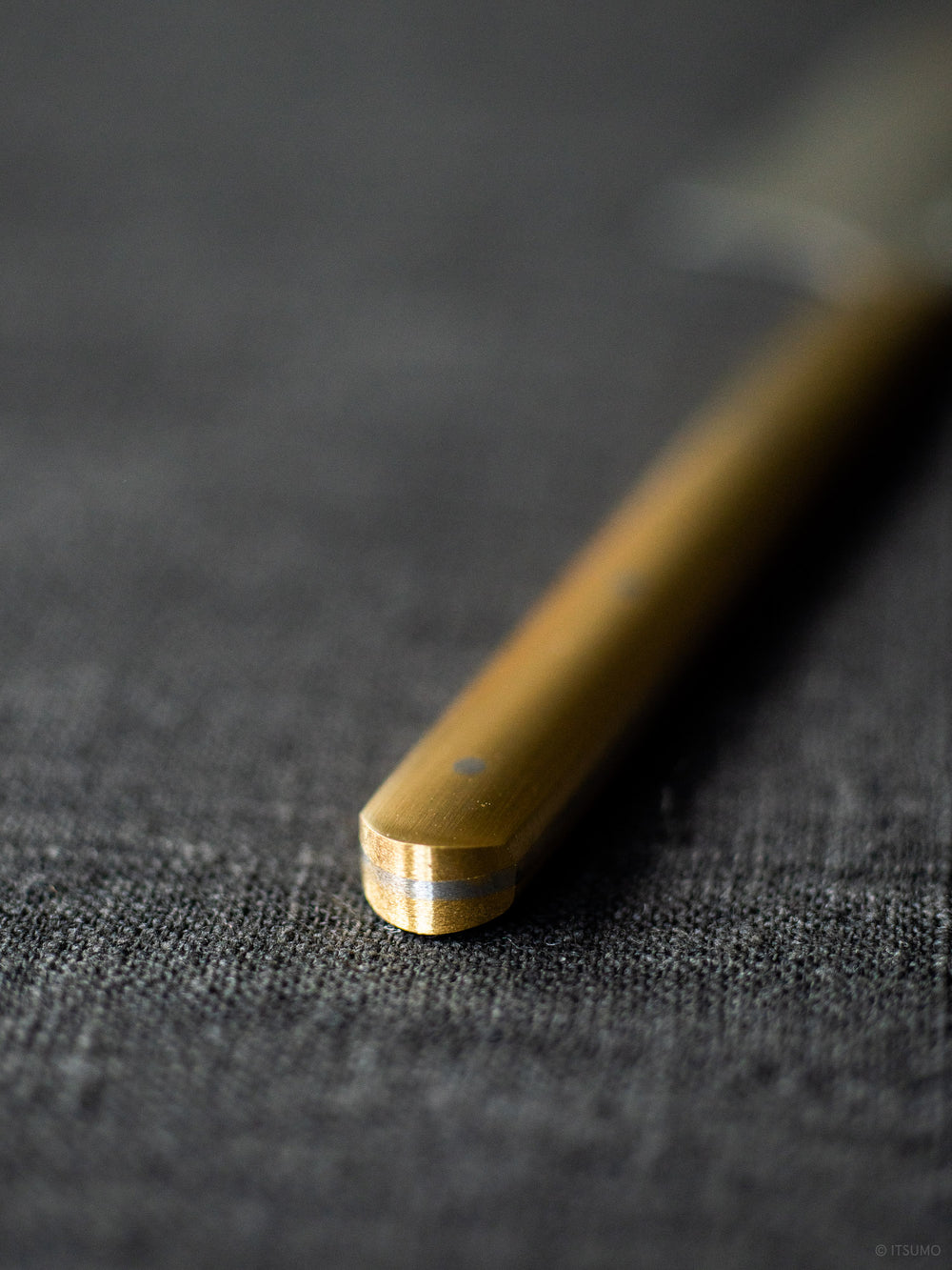 Azmaya stainless steel cheese knife with a close up of the Brass handle