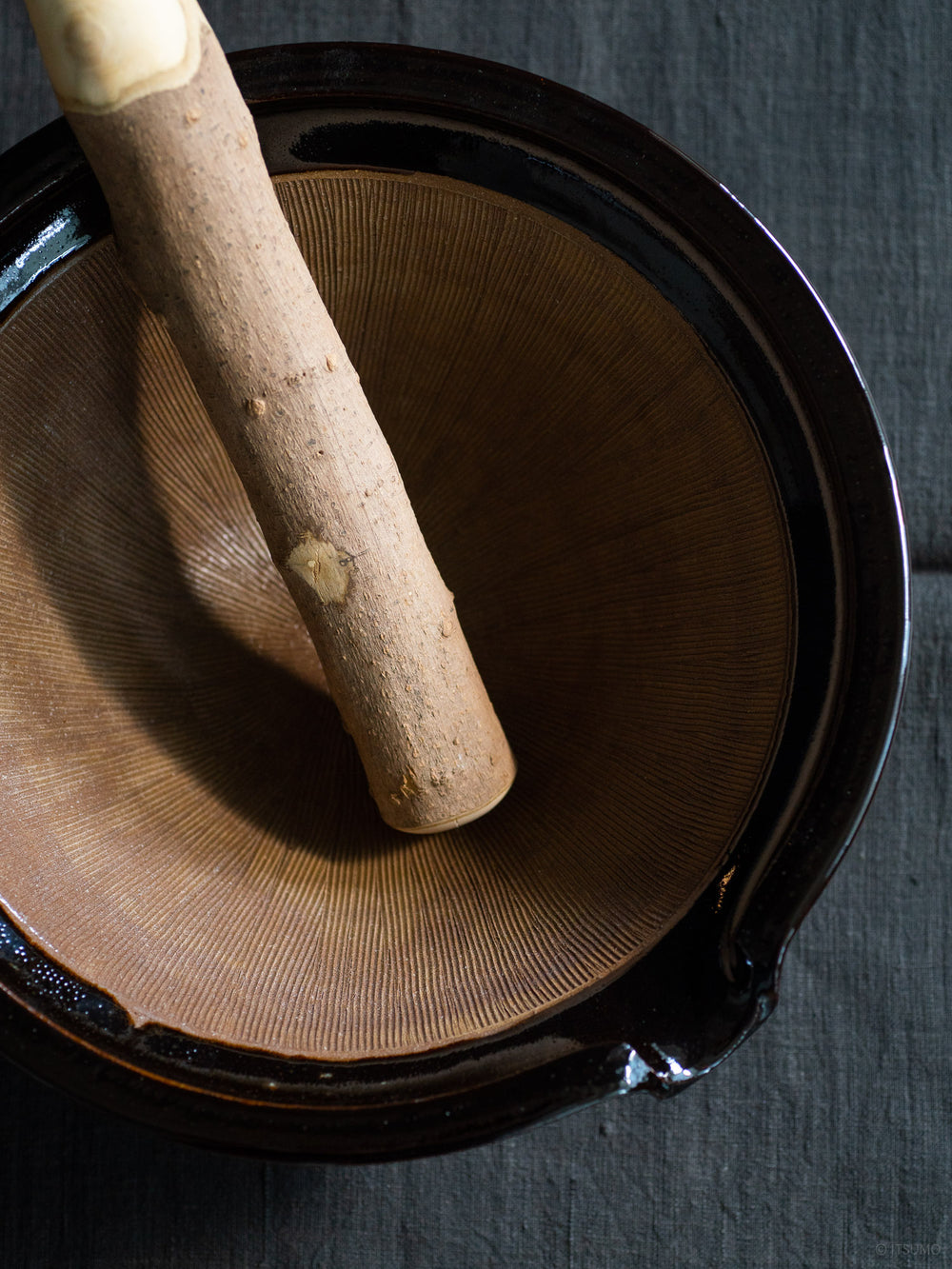Azmaya's extra large iga suribachi mortar showing a textured ceramic inside and a wooden pestle leaning against the side