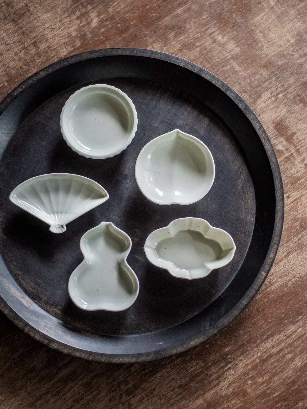 Five small Azmaya porcelain dishes in sekkai glaze shaped in traditional Japanese motifs like peach, fan, sunflower, quince, and bottle gourd