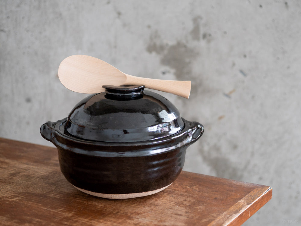 Miyajima rice scoop on top of a black iga-ware donabe pot