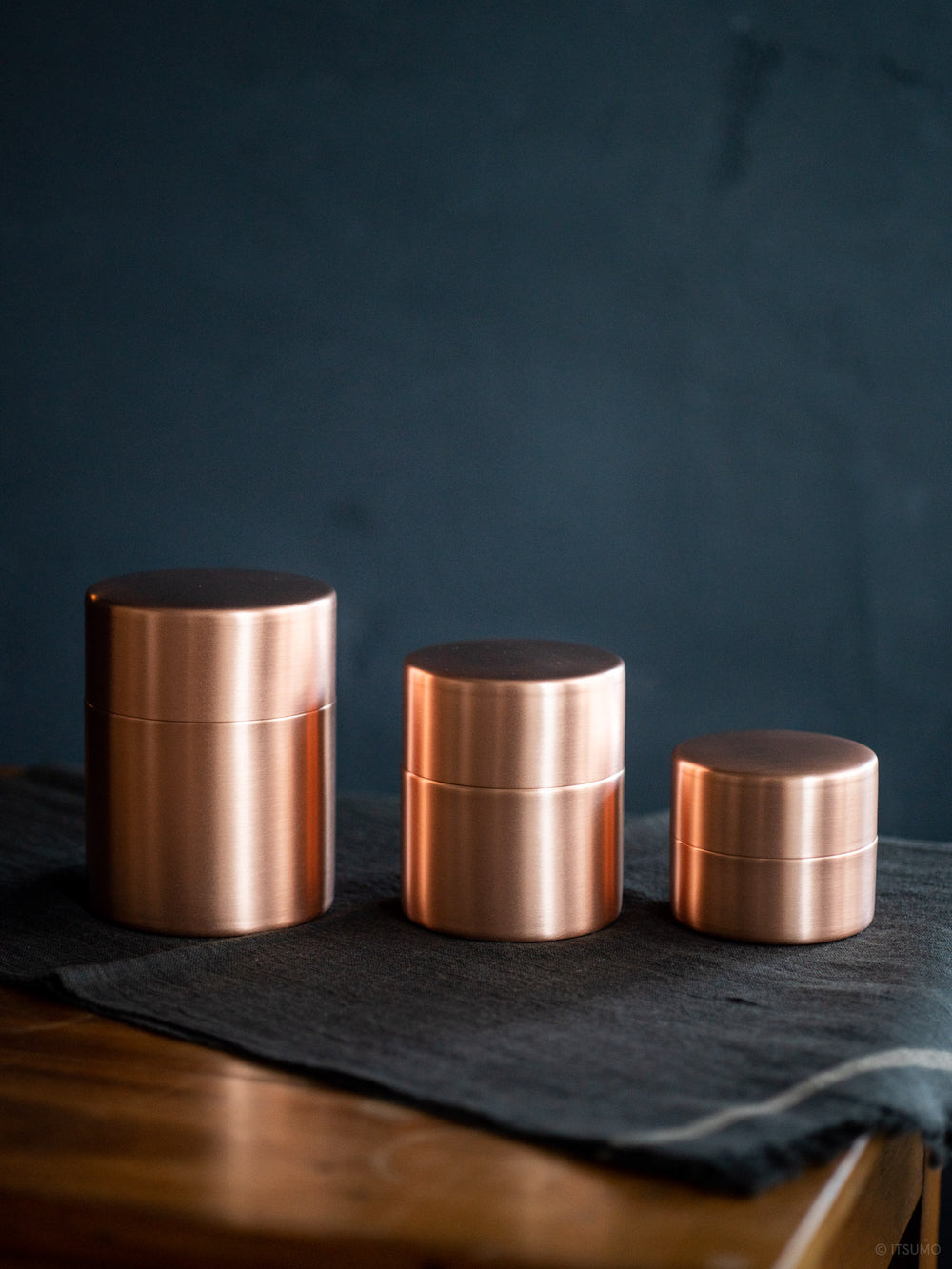 Three Azmaya copper tea canisters next to each showing showing small, medium and large sizes