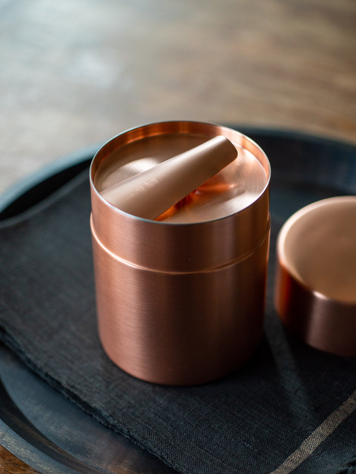 Azmaya copper tea scoop on top of a copper tea canister