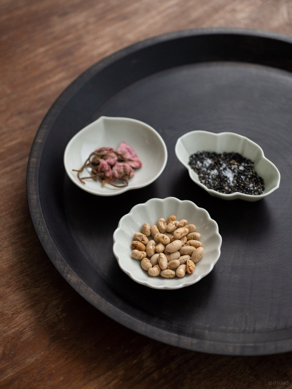 Three small Azmaya porcelain dishes holding beans, salt and dried flowers