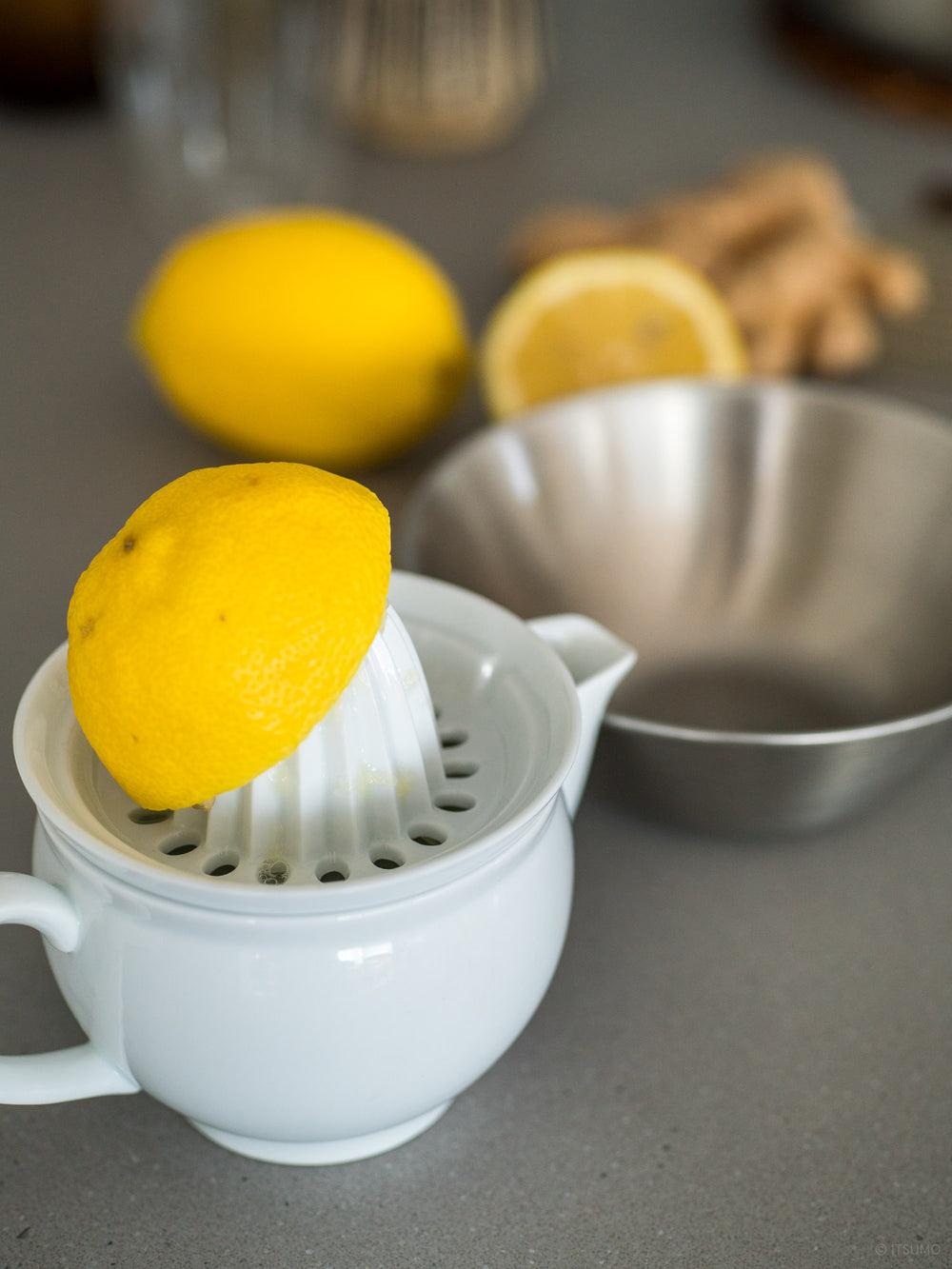 Lemons being squeezed with an Azmaya white porcelain citrus juicer
