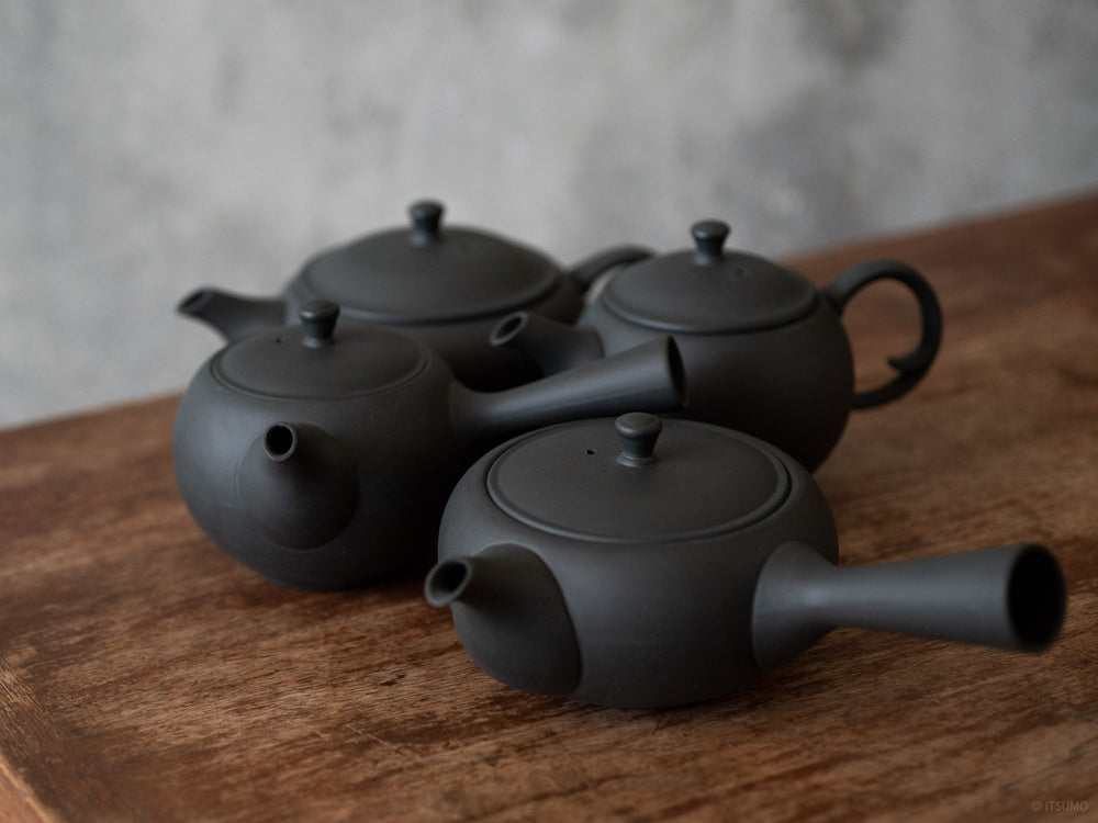 Four Azmaya teapots in round and oval shapes in unglazed matte black ceramic Tokoname ware